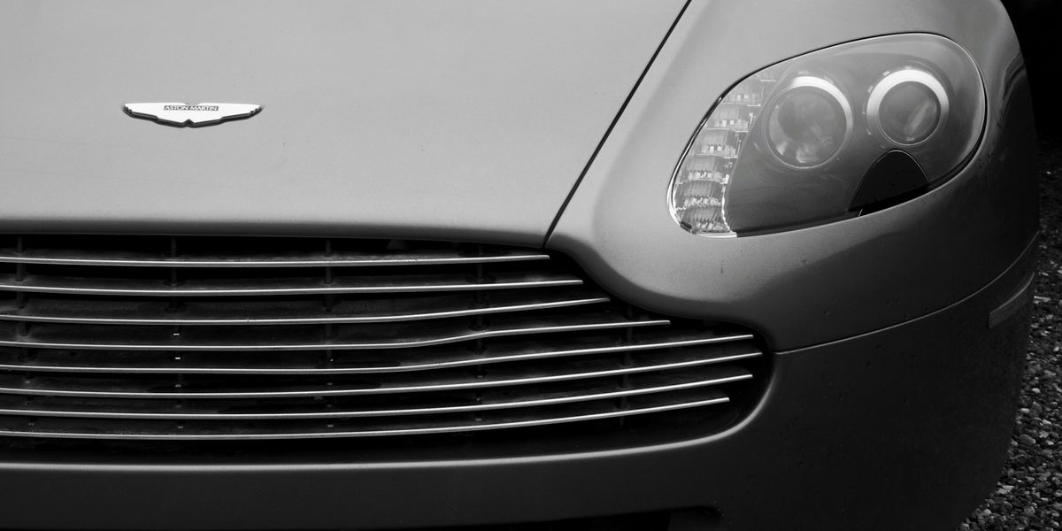 Calandre et phare d’une voiture de grand tourisme gris argent, en noir et blanc