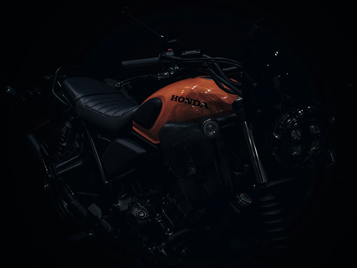 Moto noire et orange en clair-obscur sur fond noir